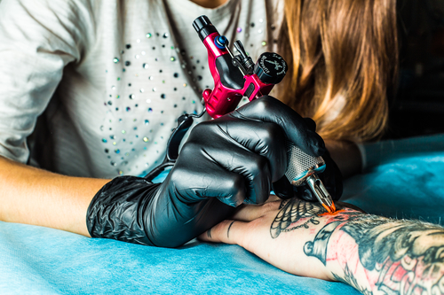 Tatovør igang med at tatovere arm