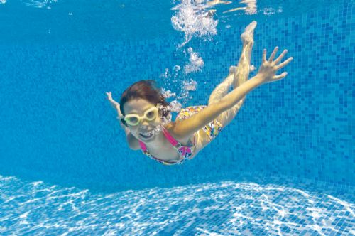 Barn svømmer under vandet