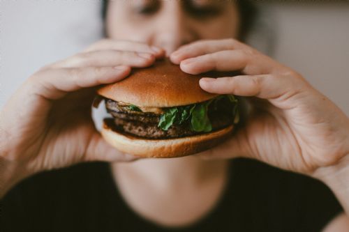 Kvinde spiser burger. Closeup af burger