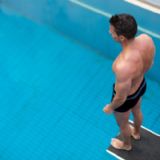 Mand der står på vippen i svømmehal