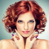 Portræt af hårmodel med rødt, krøllet hår og lilla negle