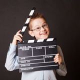 Smilende dreng med clapboard