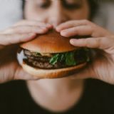 Kvinde spiser burger. Closeup af burger