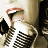 Billede af en kvinde som synger i en mikrofon